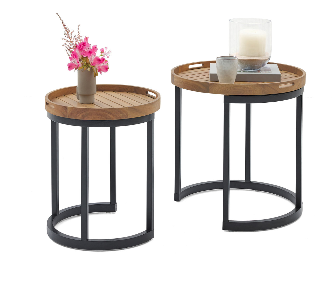 Dva okrúhle príručné stolíky s drevenou doskou a čiernym kovovým rámom. Na jednom stolíku je váza s ružovými kvetmi, na druhom sviečka v sklenenej nádobe a šálka.