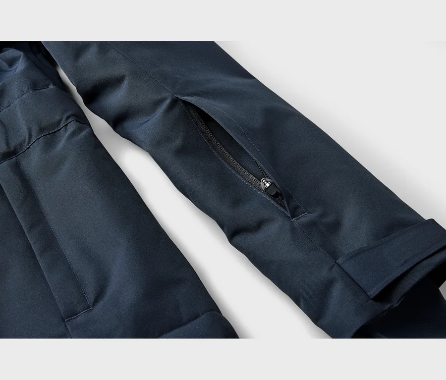 Detail tmavomodrého rukáva bundy s čiastočne otvoreným vreckom na zips.