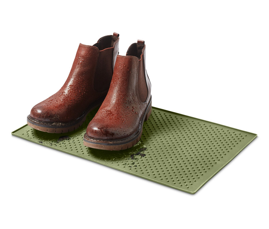 Dve hnedé topánky stoja na zelenej podložke pod misku na kŕmenie.