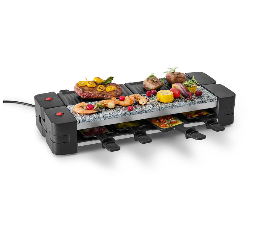 Sklopný raclette gril s mäsom, krevetami a zeleninou navrchu a panvicami dole.