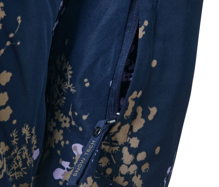 Detail lyžiarskej bundy s polovičným zipsom a otvoreným vreckom na zips.