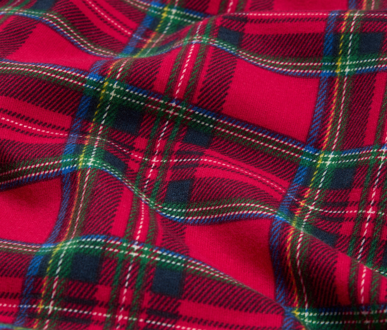Detailný záber červenej látky so vzorom tartan.