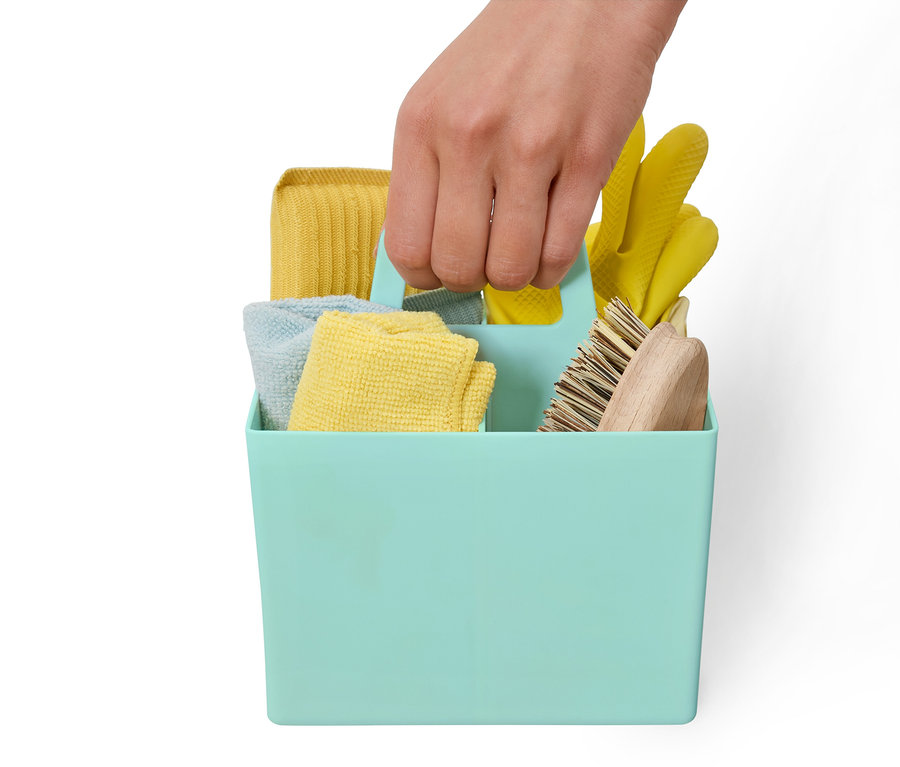 Ruka drží modrozelený úložný box s čistiacimi prostriedkami.