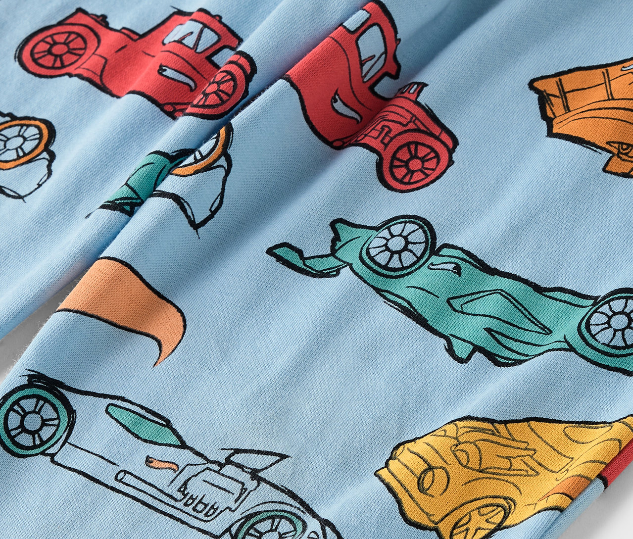Svetlomodrá látka s potlačou farebných áut.