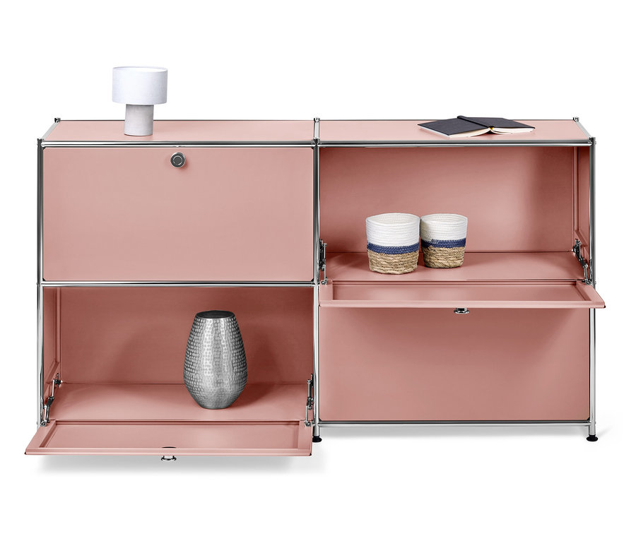 Ružová skrinka s otvorenými dvierkami, na ktorej stojí lampa, váza, dva košíky a zápisník.