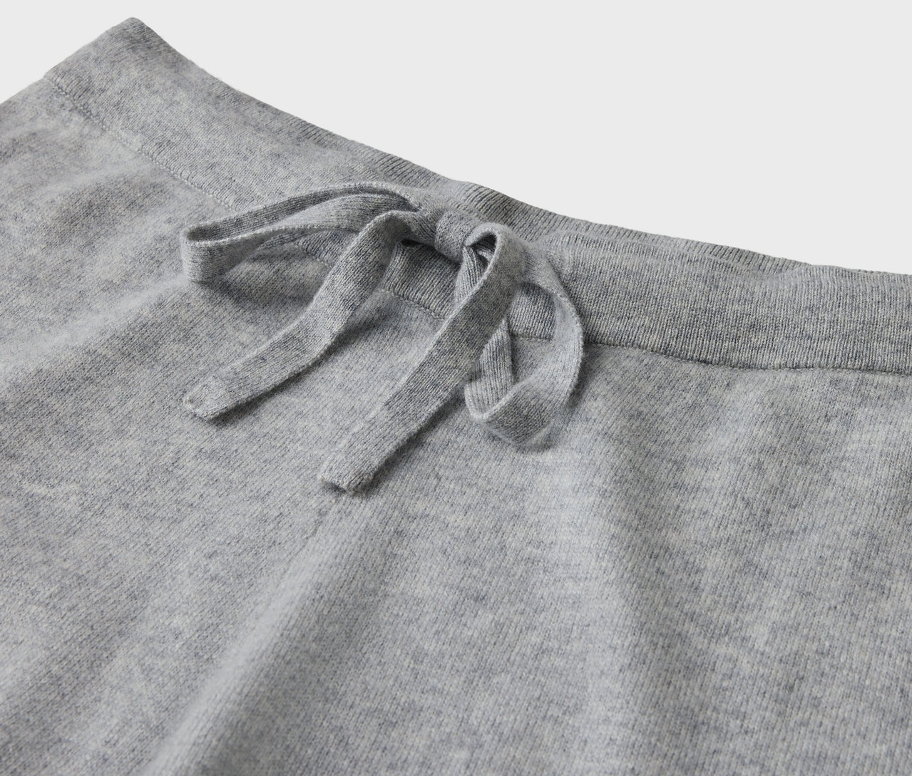 Detail sivých teplákov so sťahovacou šnúrkou.