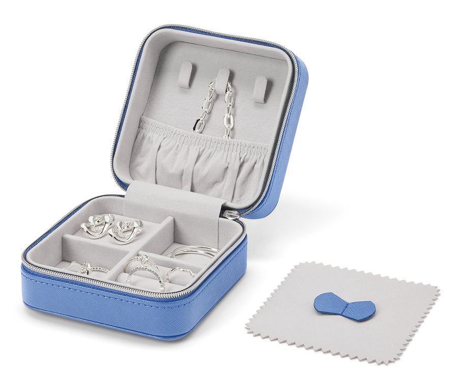 Otvorená modrá šperkovnica so striebornými šperkami a leštiacou handričkou.