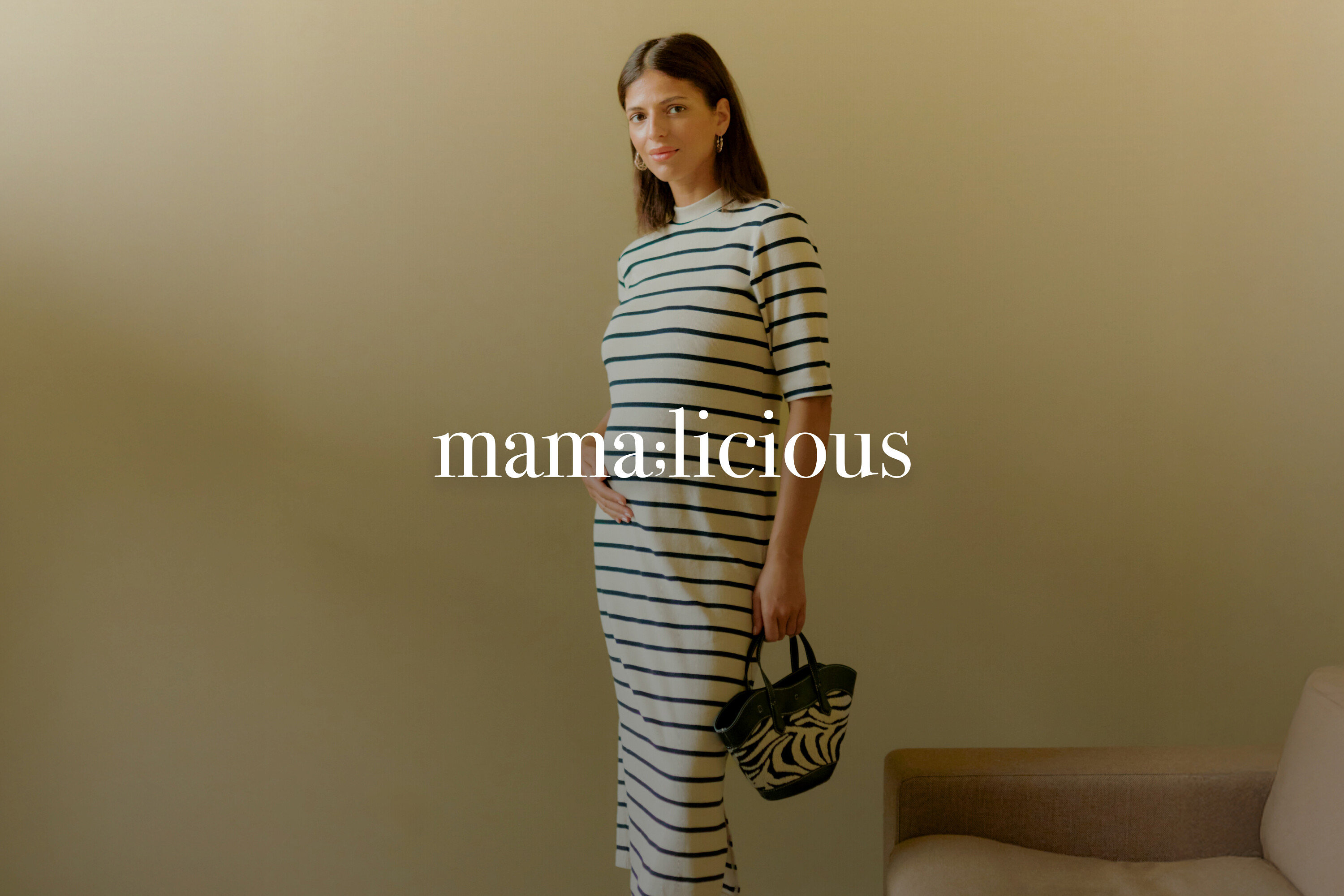 Tehotná žena má na sebe pásikavé šaty a drží kabelku so zebrou.