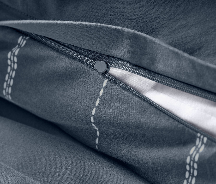 Detail sivej posteľnej bielizne zo zimného džerseja so zipsom.