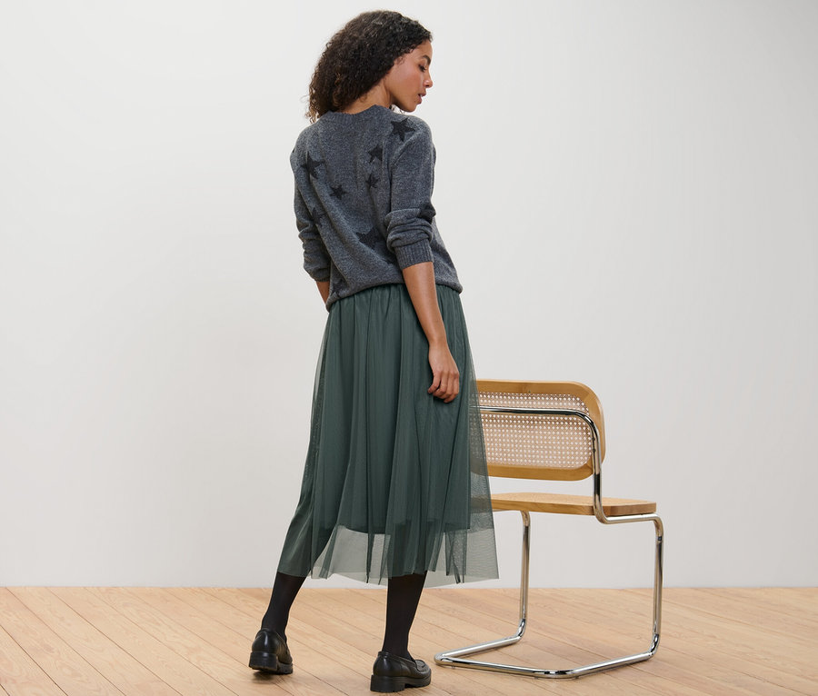 Žena stojí a má na sebe tylovú sukňu.