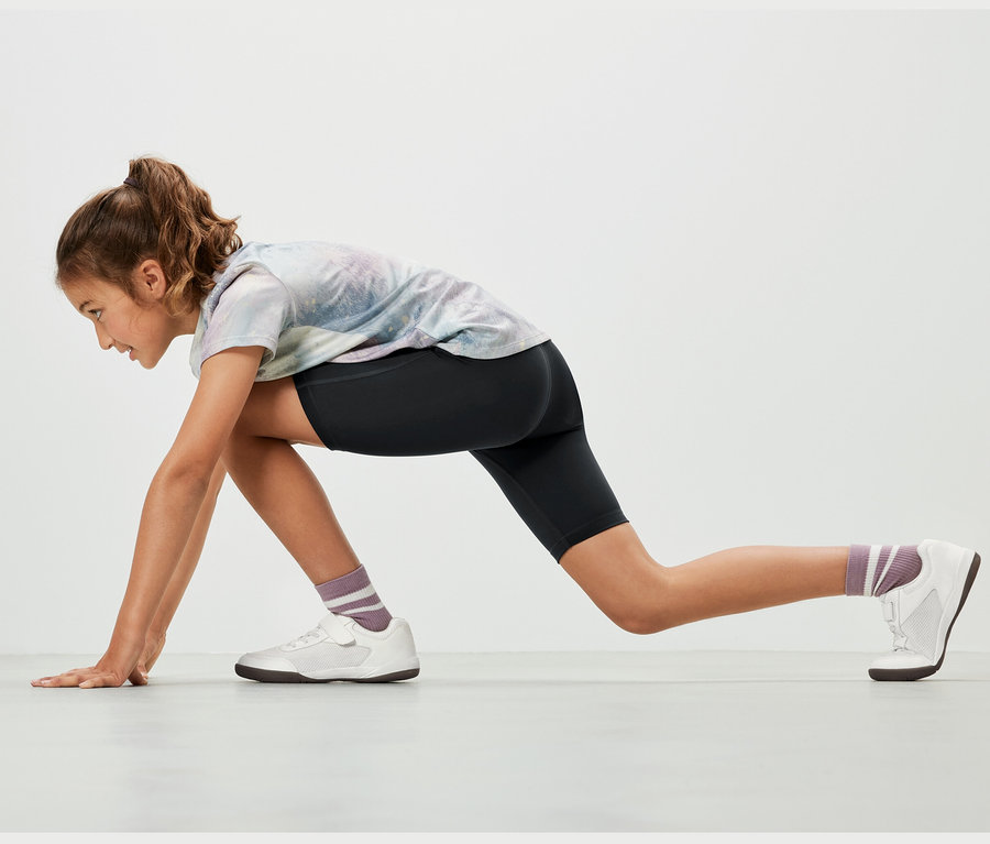 Dievča v športovej pozícii má na sebe čierne detské cyklistické šortky, 2 ks.