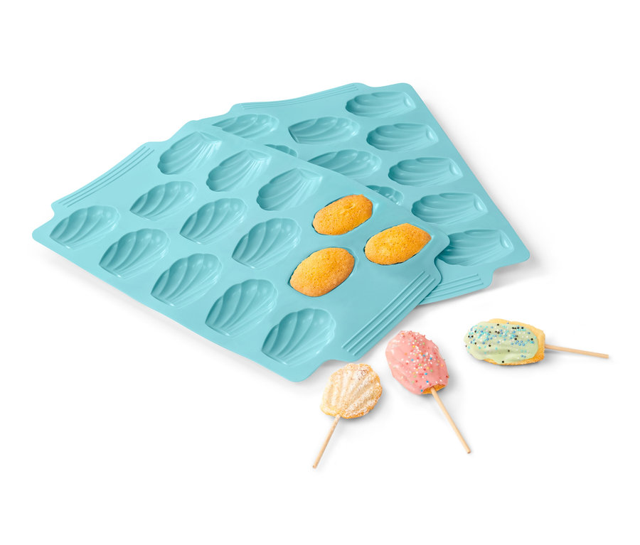 Dve svetlomodré formy na pečenie madleniek, 2 ks, s upečenými madlenkami a madlenkami na špajli.
