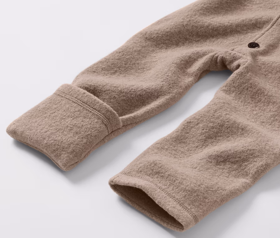 Detail hnedého detského vychádzkového overalu s vlnou merino.