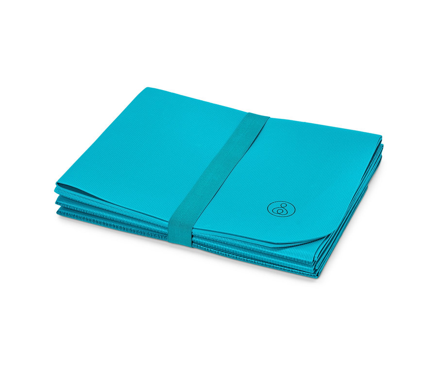 Skladacia cestovná športová podložka je zložená do obdĺžnika a stiahnutá elastickým pásikom.