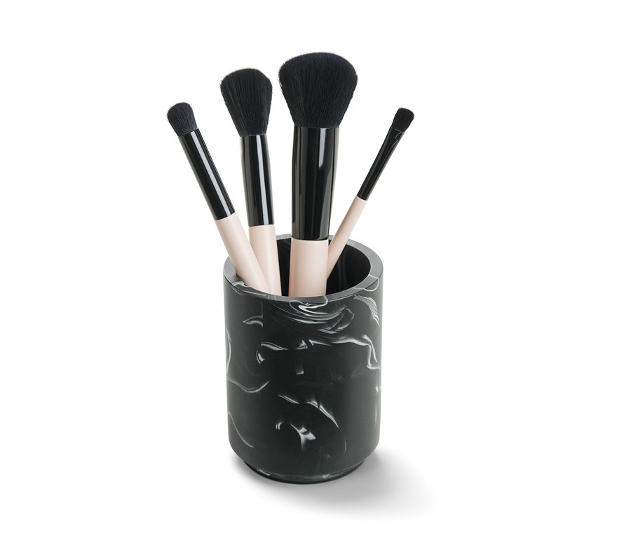Štyri štetce na make-up v mramorovanej nádobke.