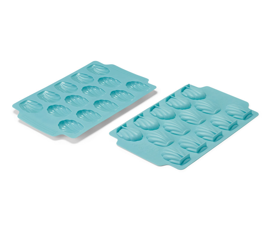 Dve svetlomodré formy na pečenie madleniek, každá s dvanástimi priehlbinami v tvare mušlí.