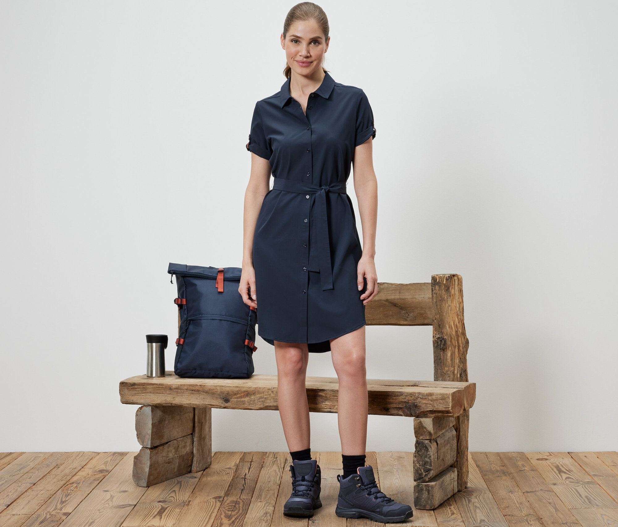 Žena stojí pred lavicou a má na sebe funkčné šaty.