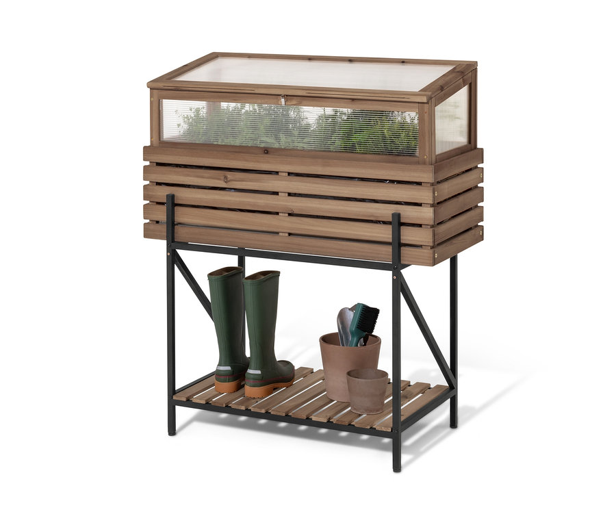 Vyvýšený záhon s nadstavcom na parenisko »Elin« stojí na čiernej polici. Na polici sú zelené gumáky a kvetináče.