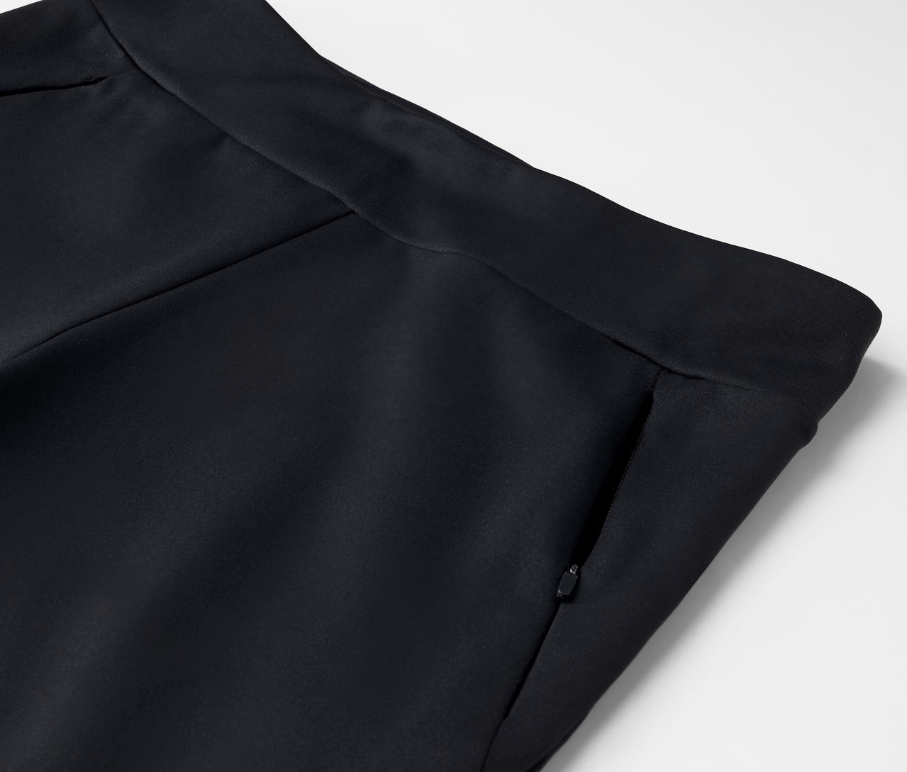 Detail čiernych nohavíc so vreckom na zips.