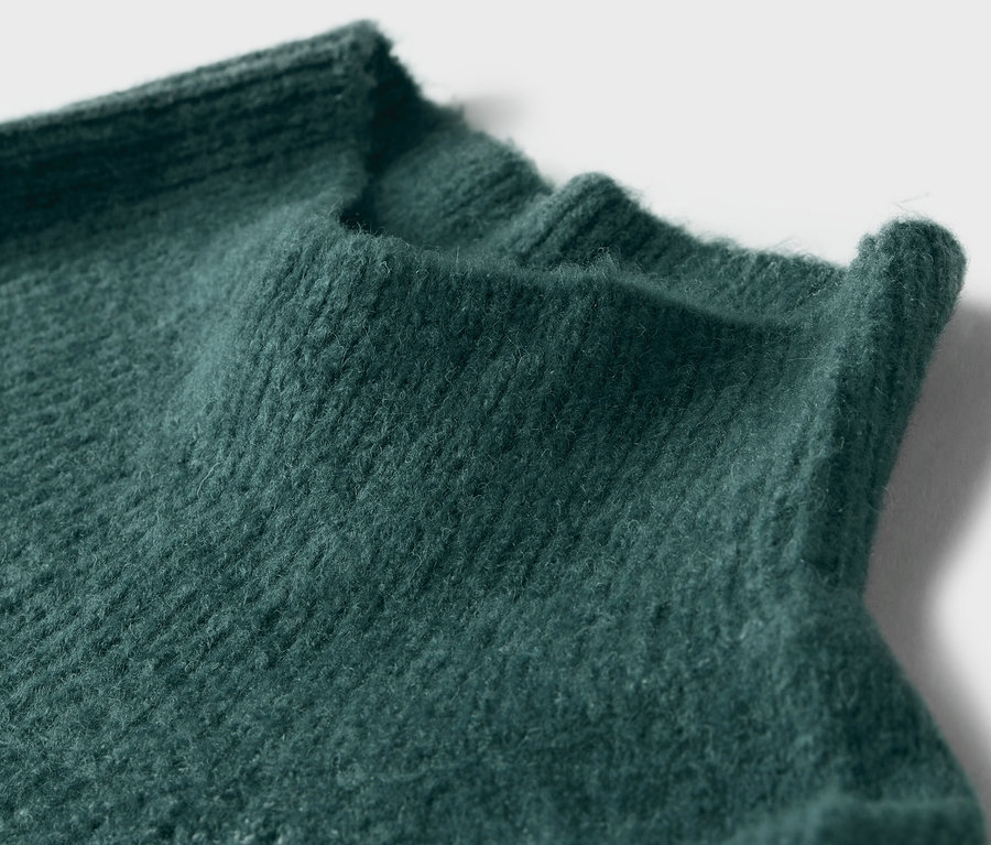 Detailný záber na zelený pletený rolák.