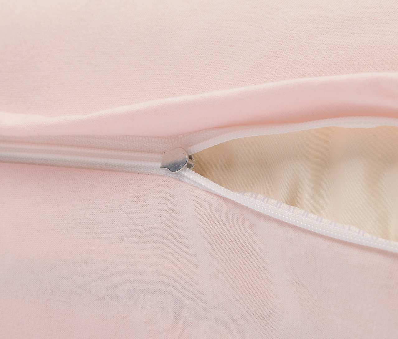 Detail ružového vankúša so strieborným zipsom.
