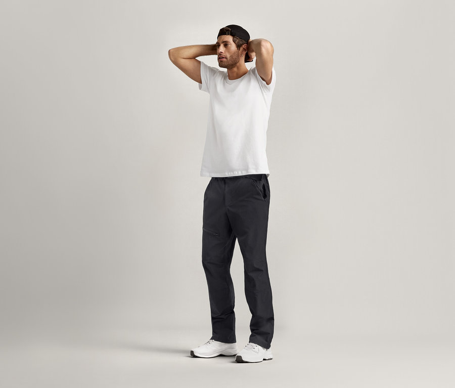 Muž pózuje s rukami za hlavou a má na sebe biele Tričká s okrúhlym výstrihom, 2 ks.