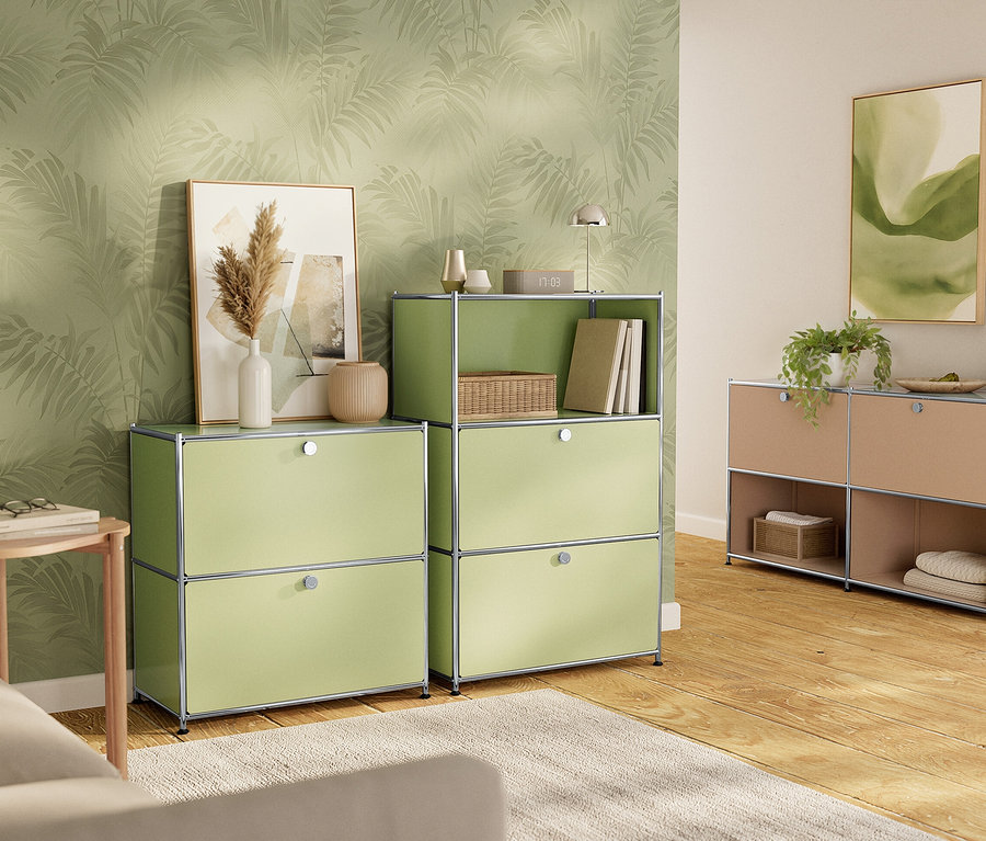 Dve zelené a jedna béžová skrinka stoja na drevenej podlahe pred stenou so vzorom listov.
