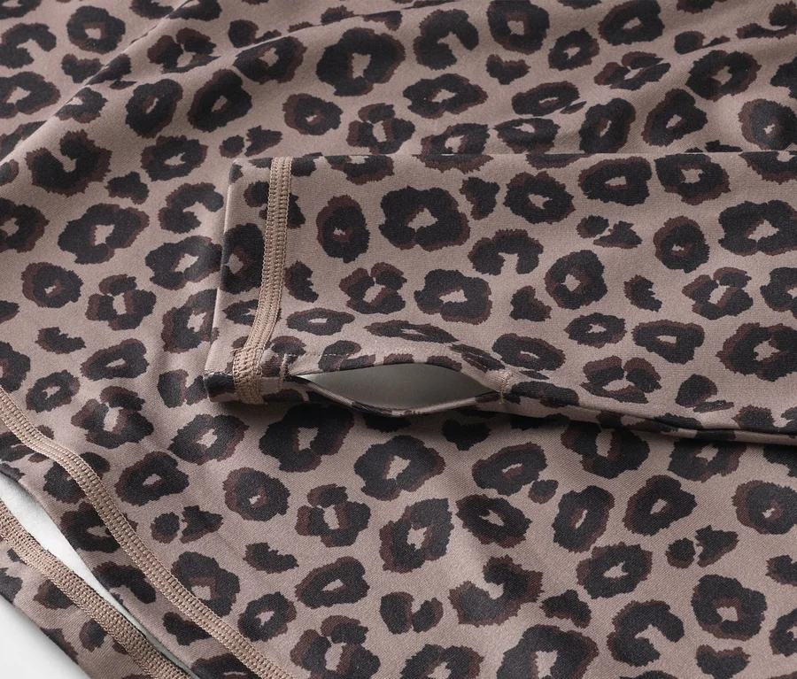 Detail športového topu s leopardím vzorom a vreckom na rukáve.