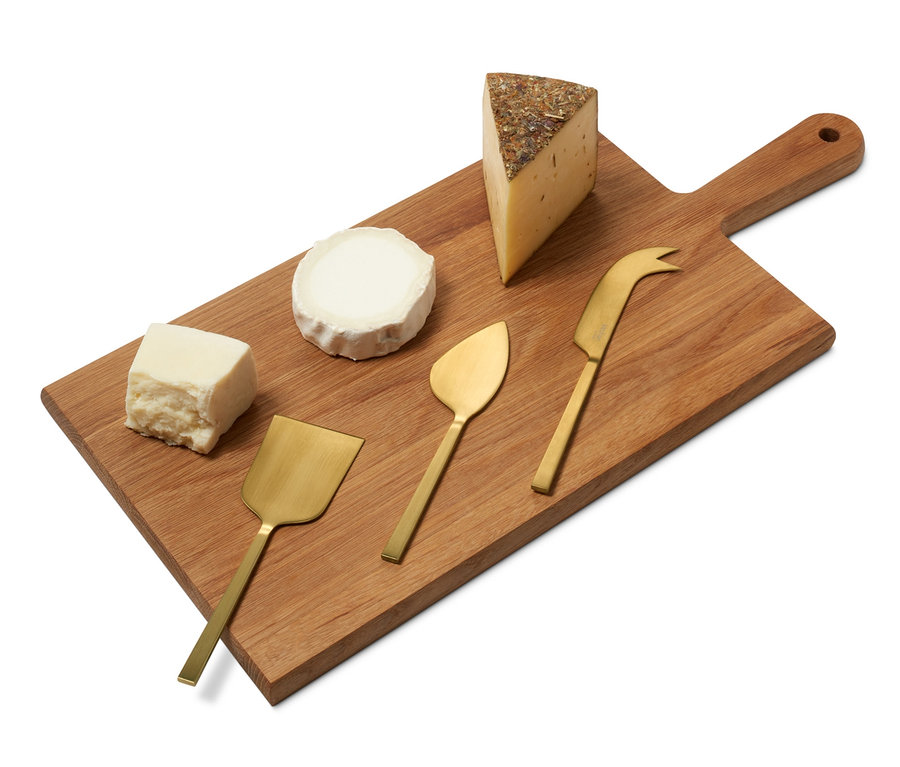 Drevená doska so syrmi a súpravou nožov na syr.