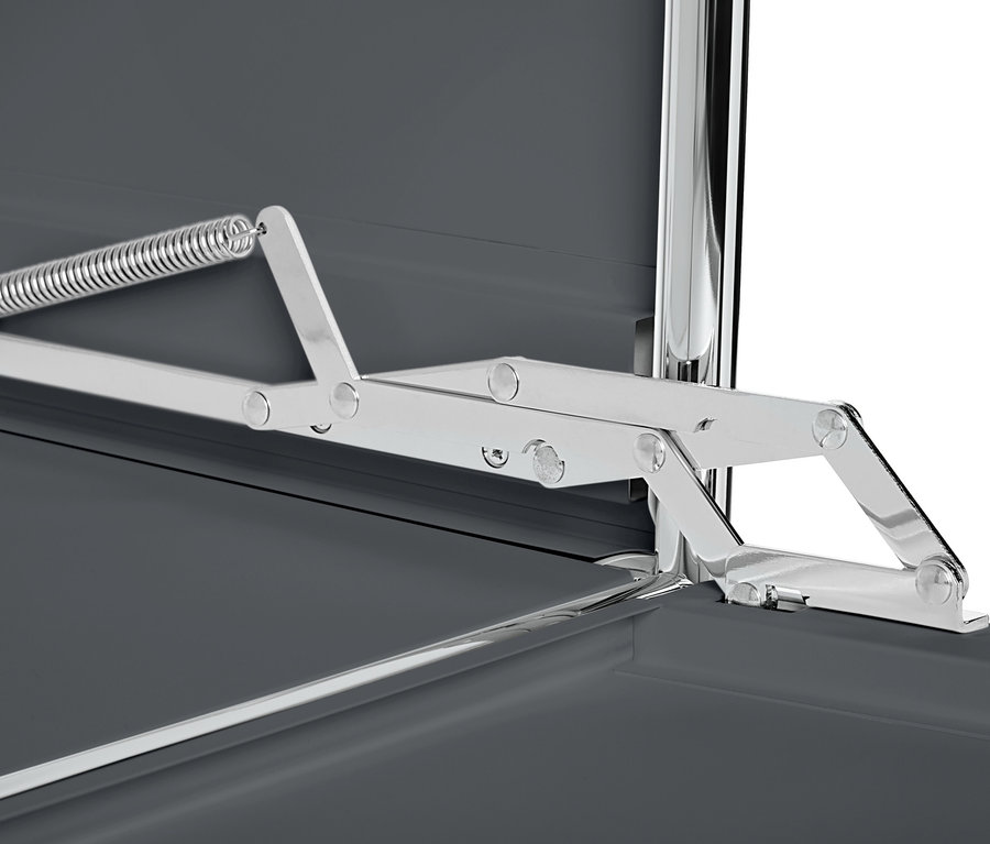 Detail šedej kovovej odkladacej skrinky »CN3« s výklopnými priehradkami a strieborným mechanizmom.