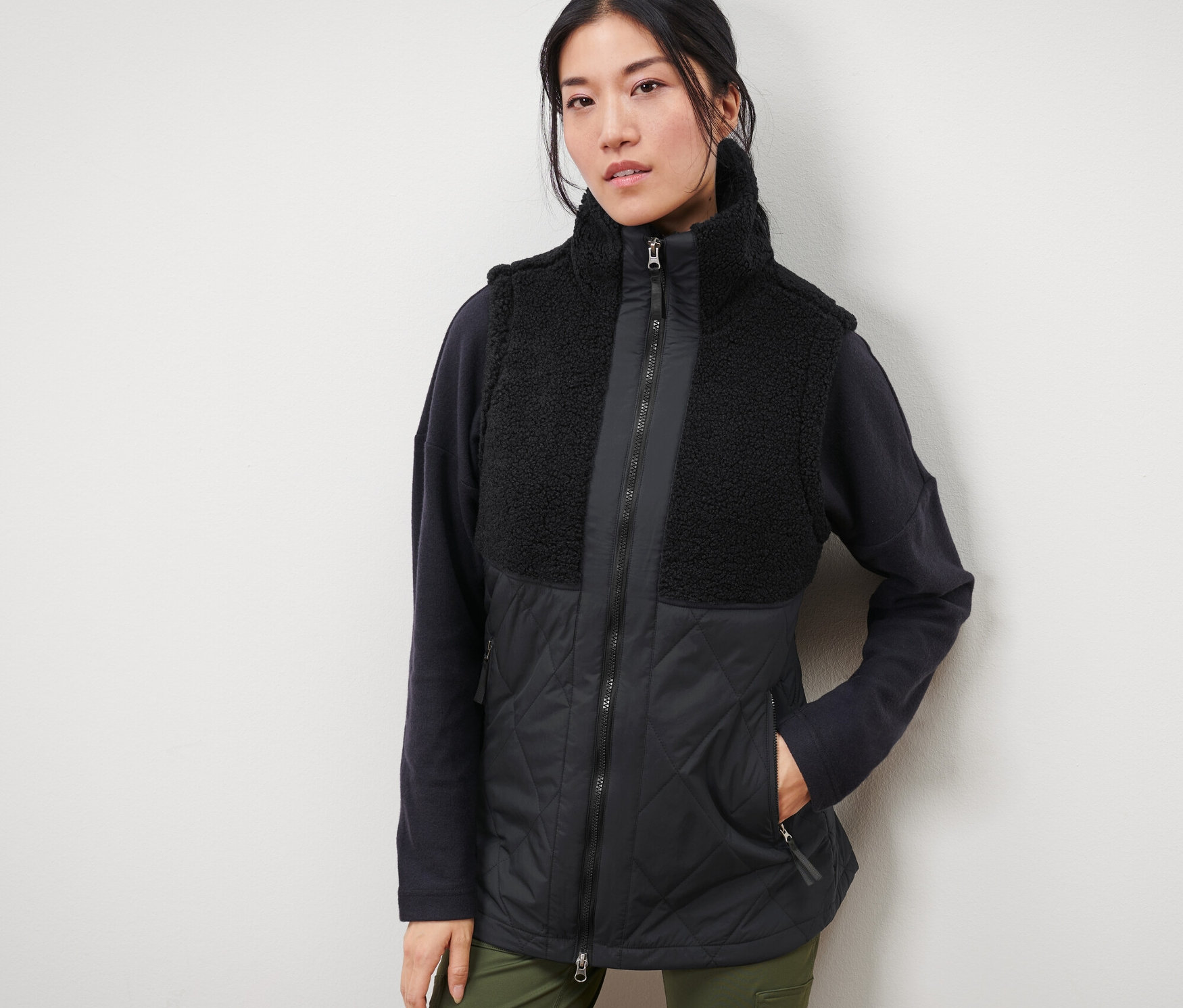 Žena má na sebe plyšovú prešívanú vestu.