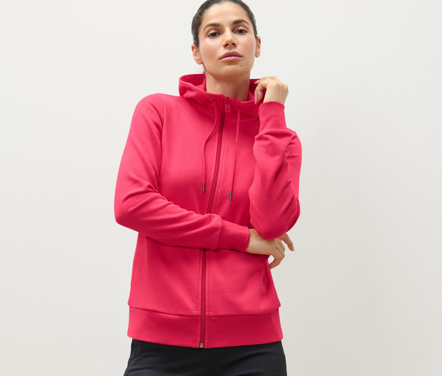 Žena má na sebe ružovú mikinu.