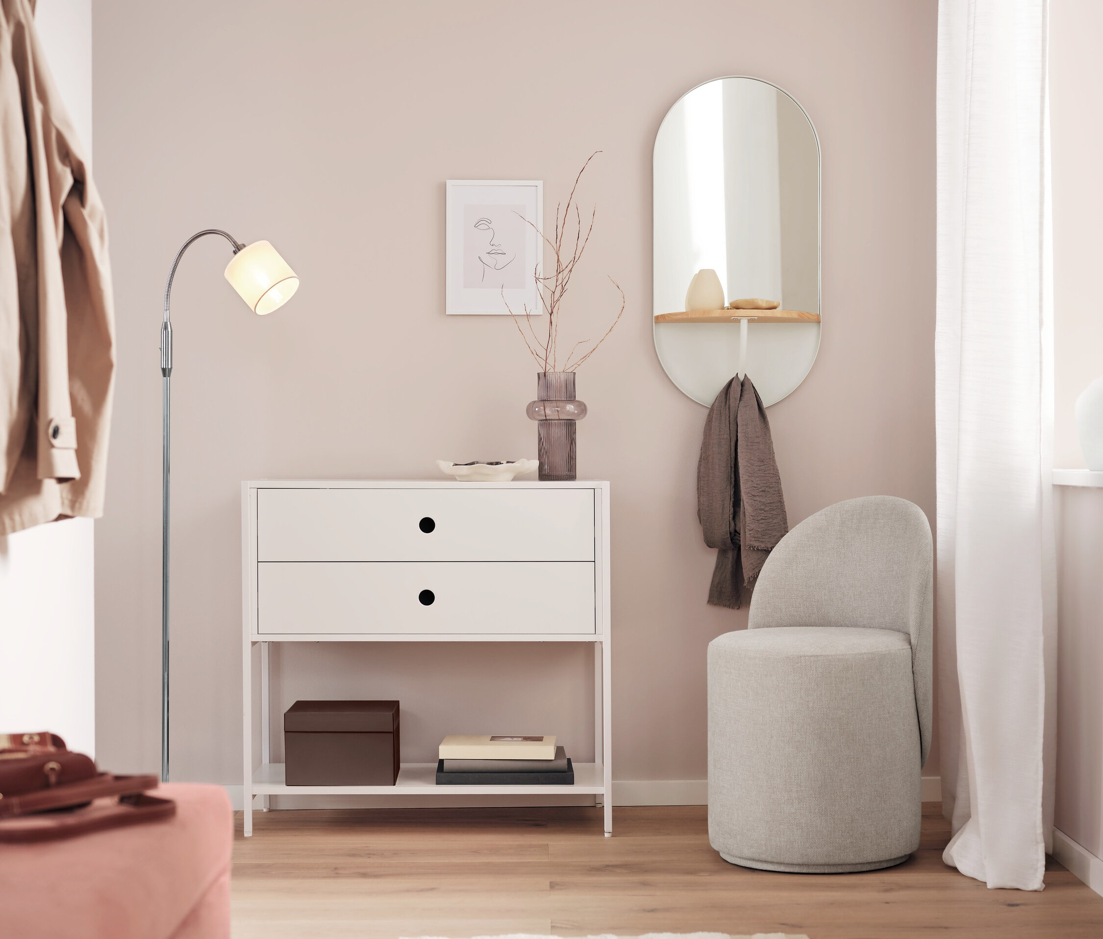 Biely stolík s dvomi zásuvkami stojí vedľa zrkadla a sivej stoličky v izbe.