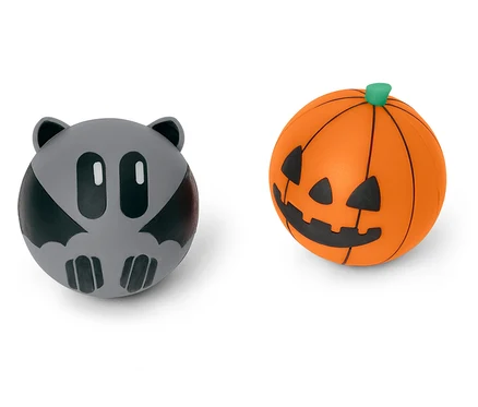 Dve halloweenske ozdobné gule: sivý netopier a oranžová tekvica.