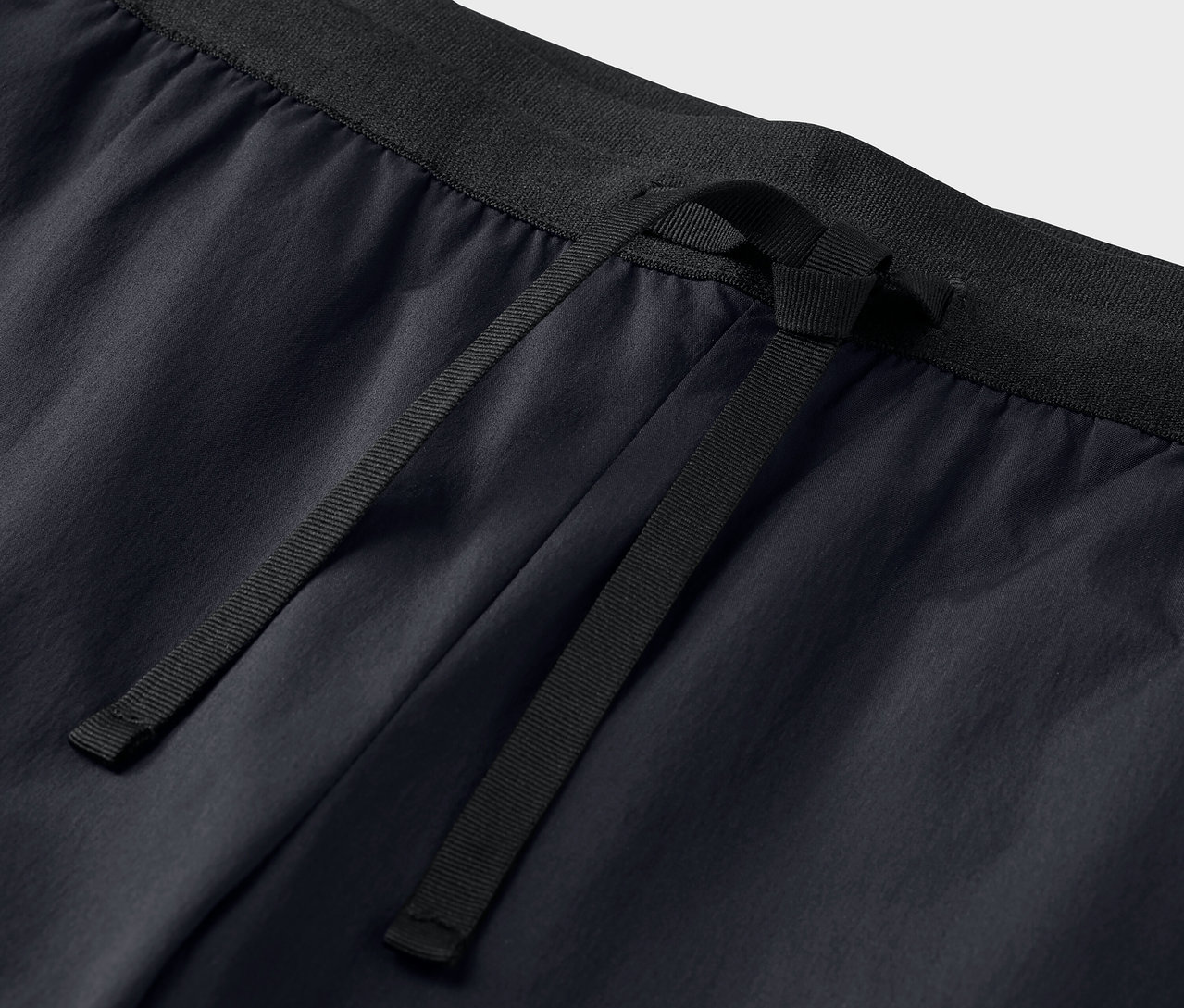 Detailný záber na čierne funkčné nohavice so sťahovacou šnúrkou.