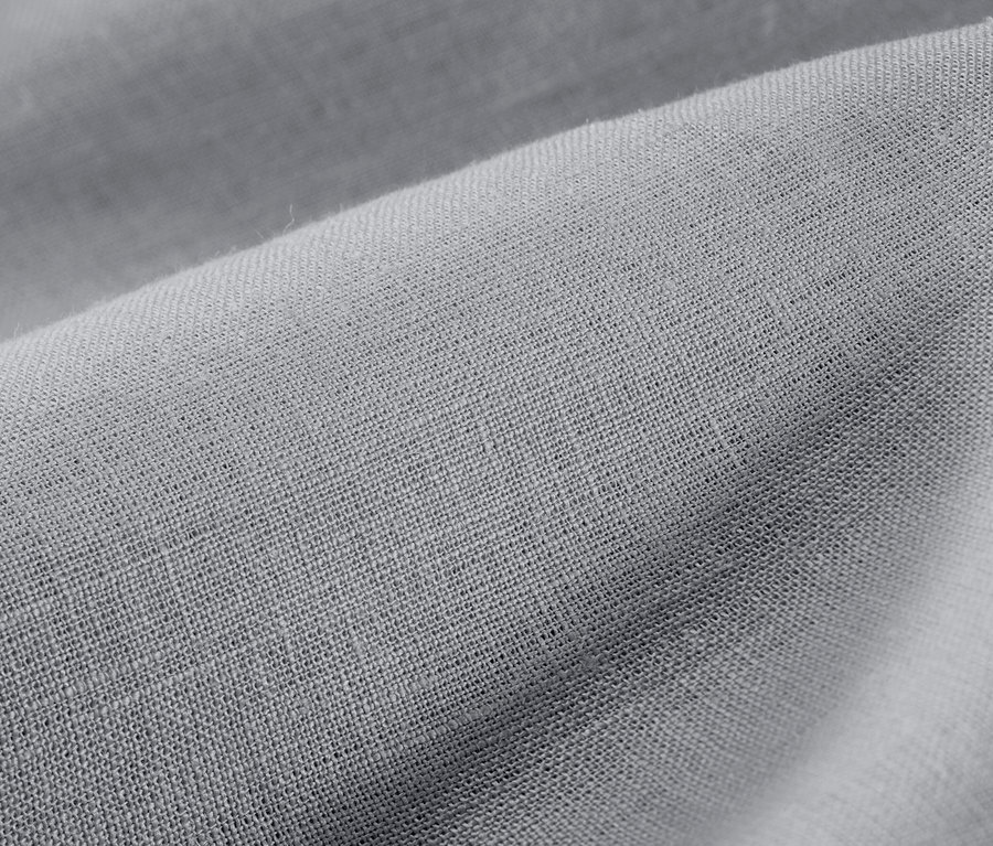 Detail šedej ľanovej posteľnej bielizne nadmernej veľkosti.