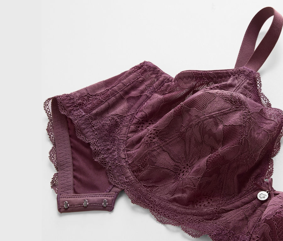 Detail fialovej podprsenky s kosticami s čipkovaným lemom.