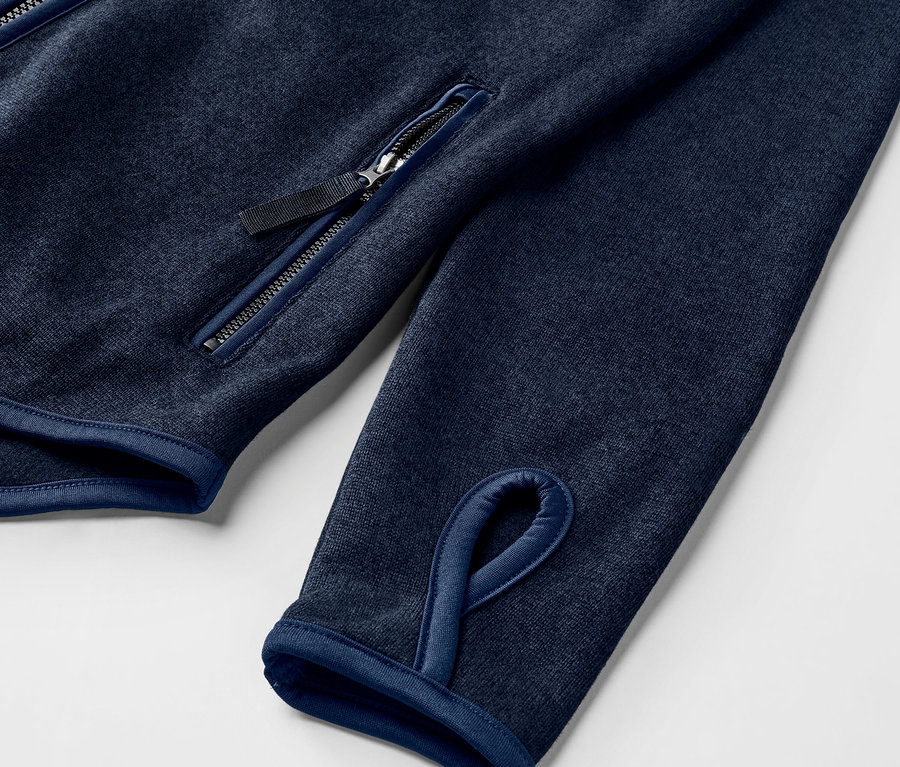Detail bundy z pleteného flísu, námornícka modrá, s otvorom na palec a vreckom na zips.