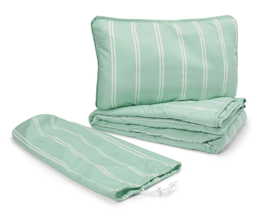 Zelený prešívaný vankúš a prikrývka s bielymi pruhmi vedľa obalu so sťahovacou šnúrkou.