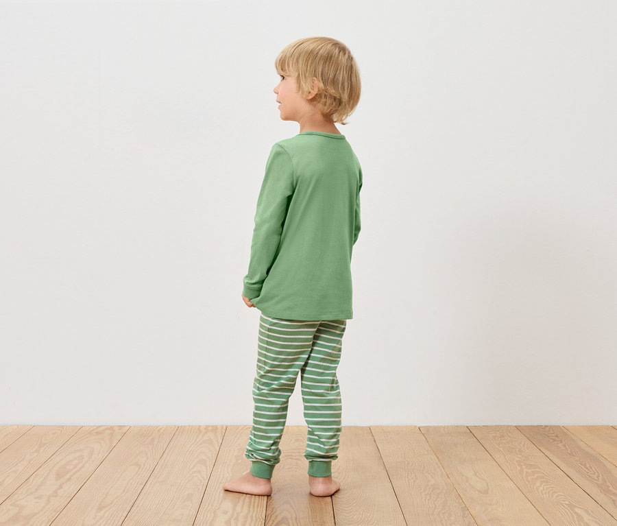Chlapec v zelenom pyžame sa pozerá doľava.