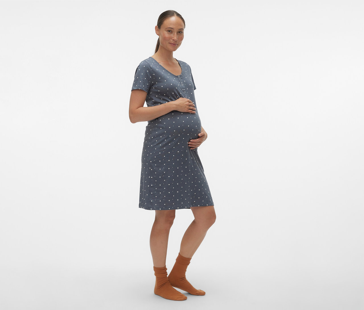 Tehotná žena drží si brucho a má na sebe modrú nočnú košeľu MAMALICIOUS »MLMIRA« s bielymi bodkami.
