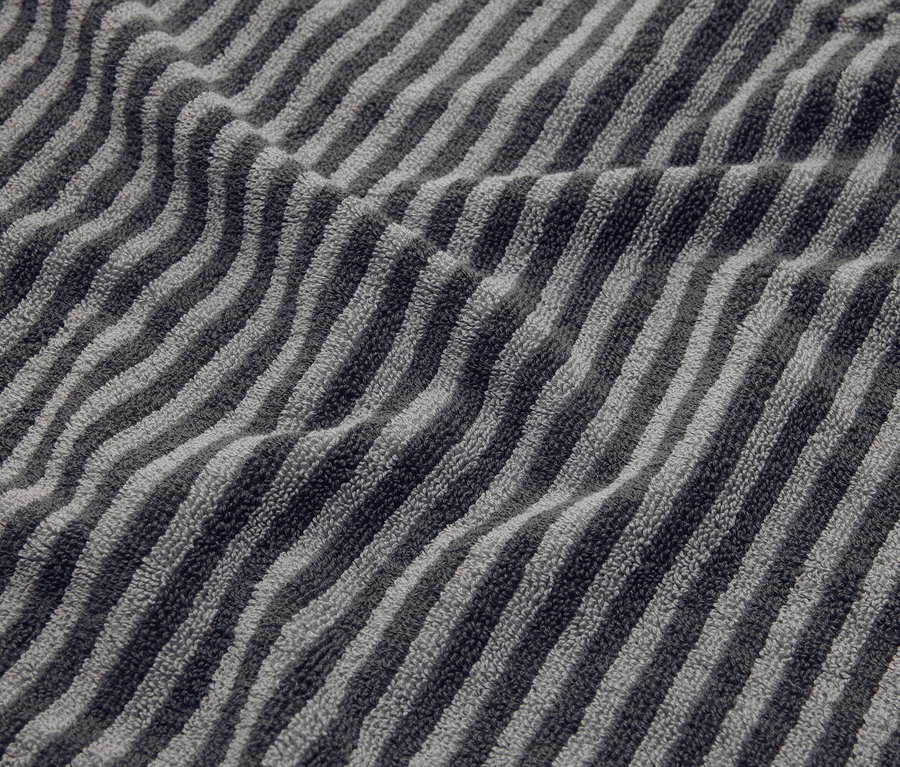 Detail záber pruhovaného sivého uteráka s záhybmi.