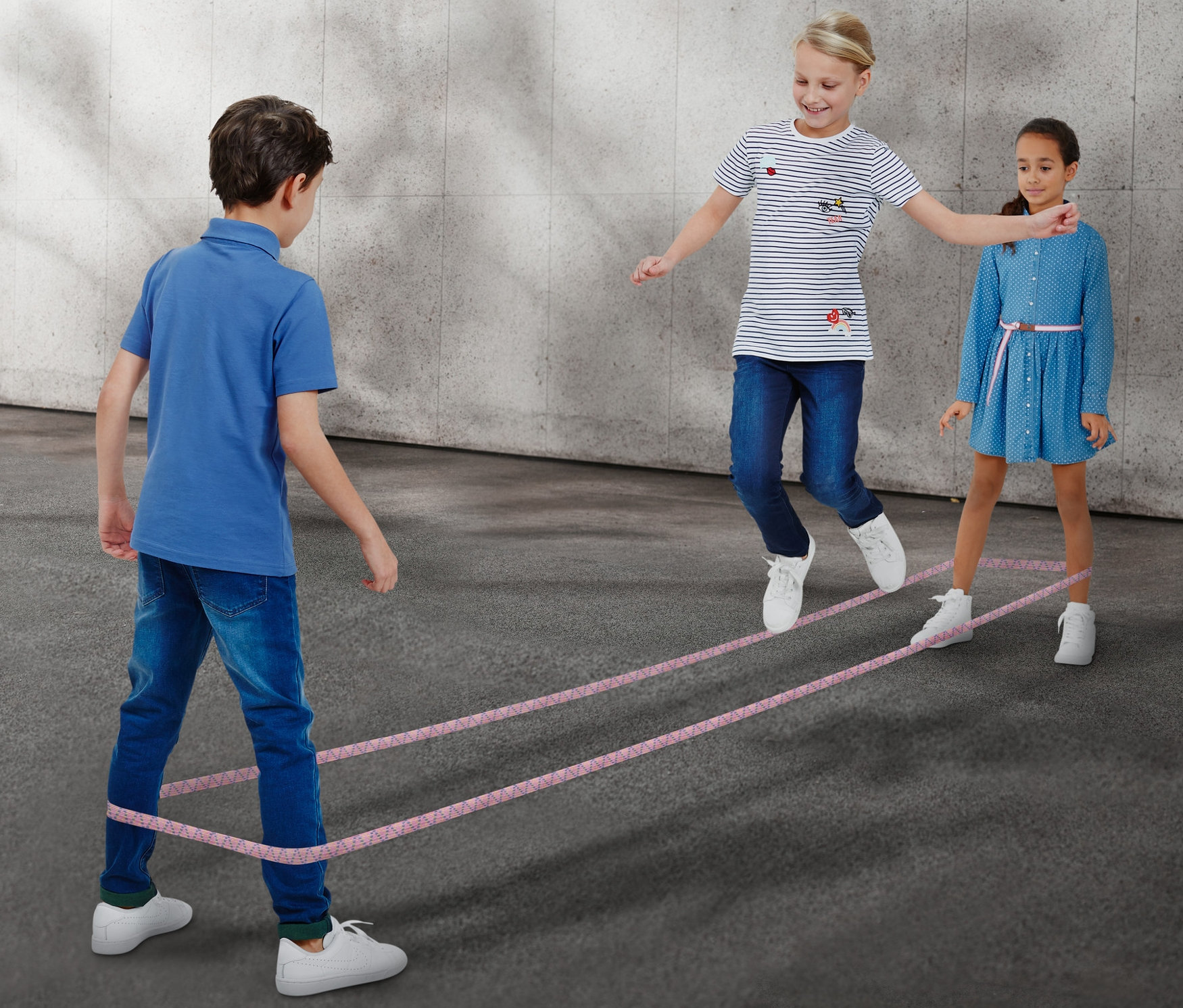 Deti hrajú gumu na skákanie.