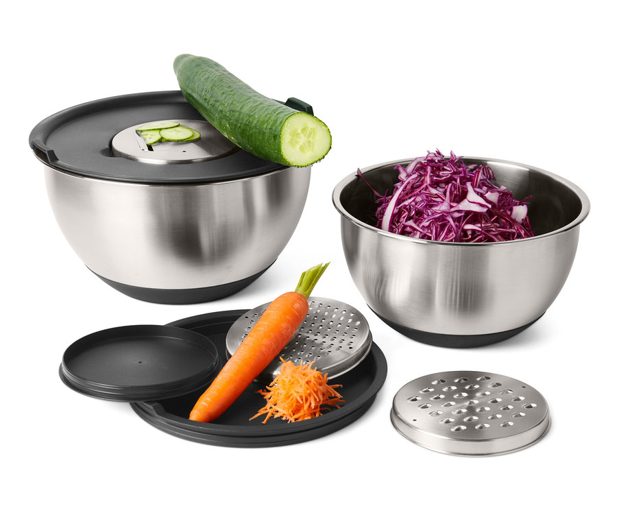 Súprava mís na šľahanie z ušľachtilej ocele s uhorkou, červenou kapustou a mrkvou na strúhadle v pozadí.