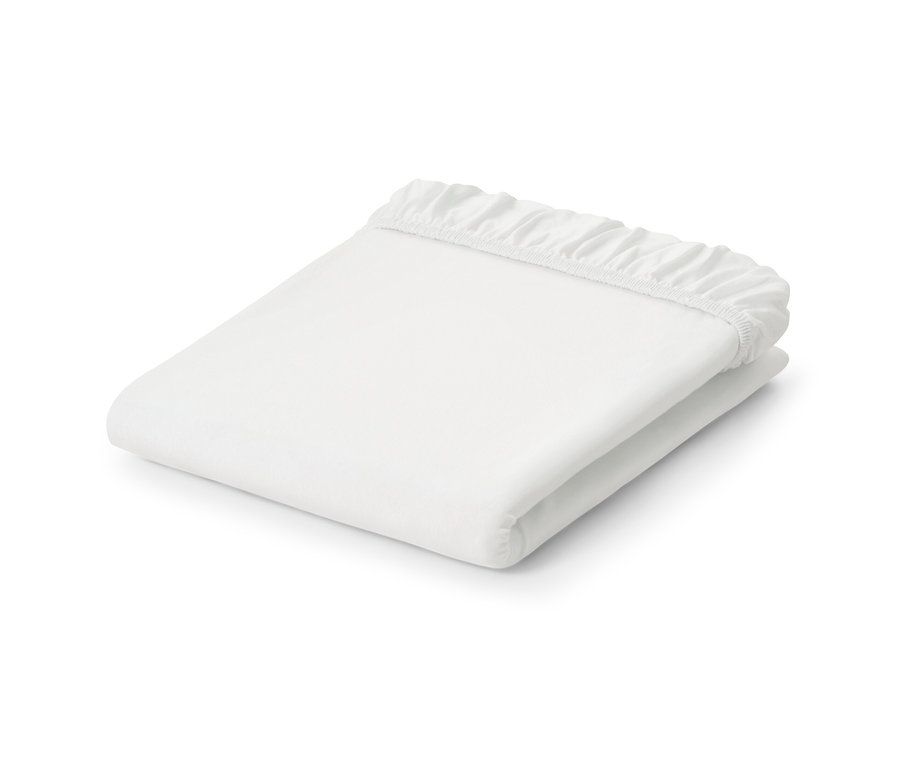 Zložené biele džersejové napínacie prestieradlo.