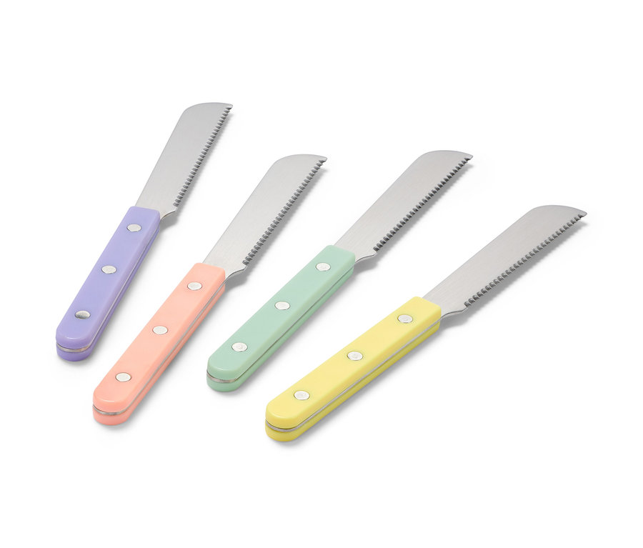Štyri raňajkové nože s farebnými rukoväťami, fialovou, broskyňovou, zelenou a žltou, ležia na bielom povrchu.