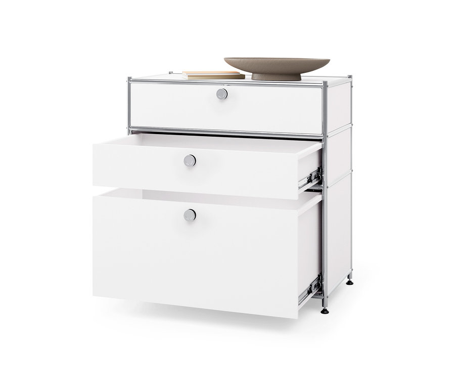 Biela kovová komoda »CN3« s tromi zásuvkami, z ktorých dve sú otvorené.