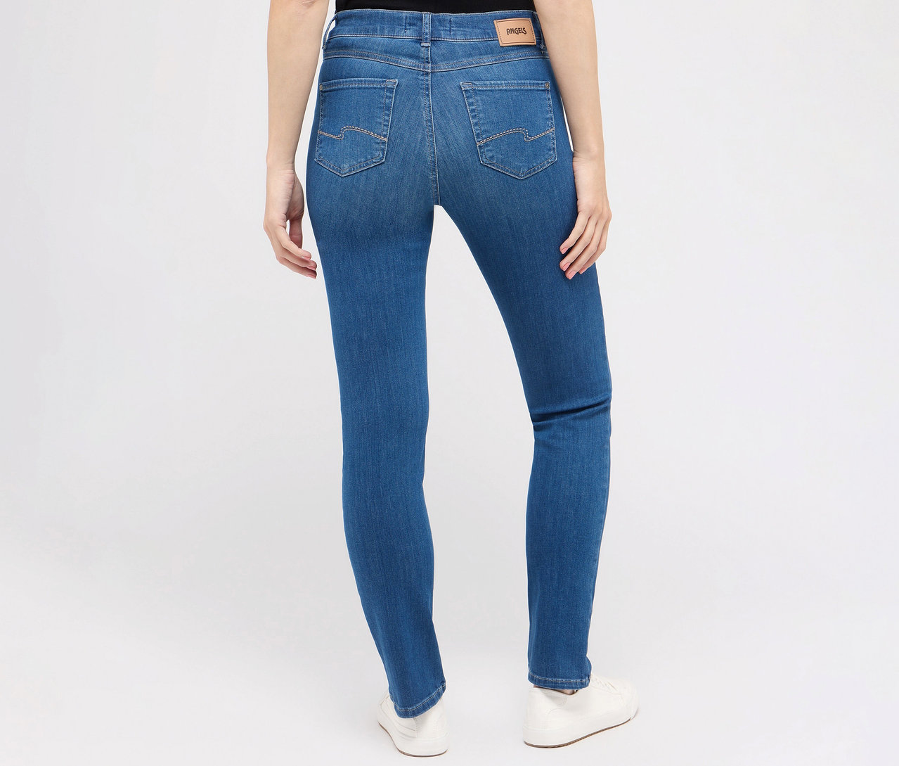 Pohľad zozadu na ženu nosiacu džínsy Angels »Cici« strih Slim Fit, modré a biele topánky.