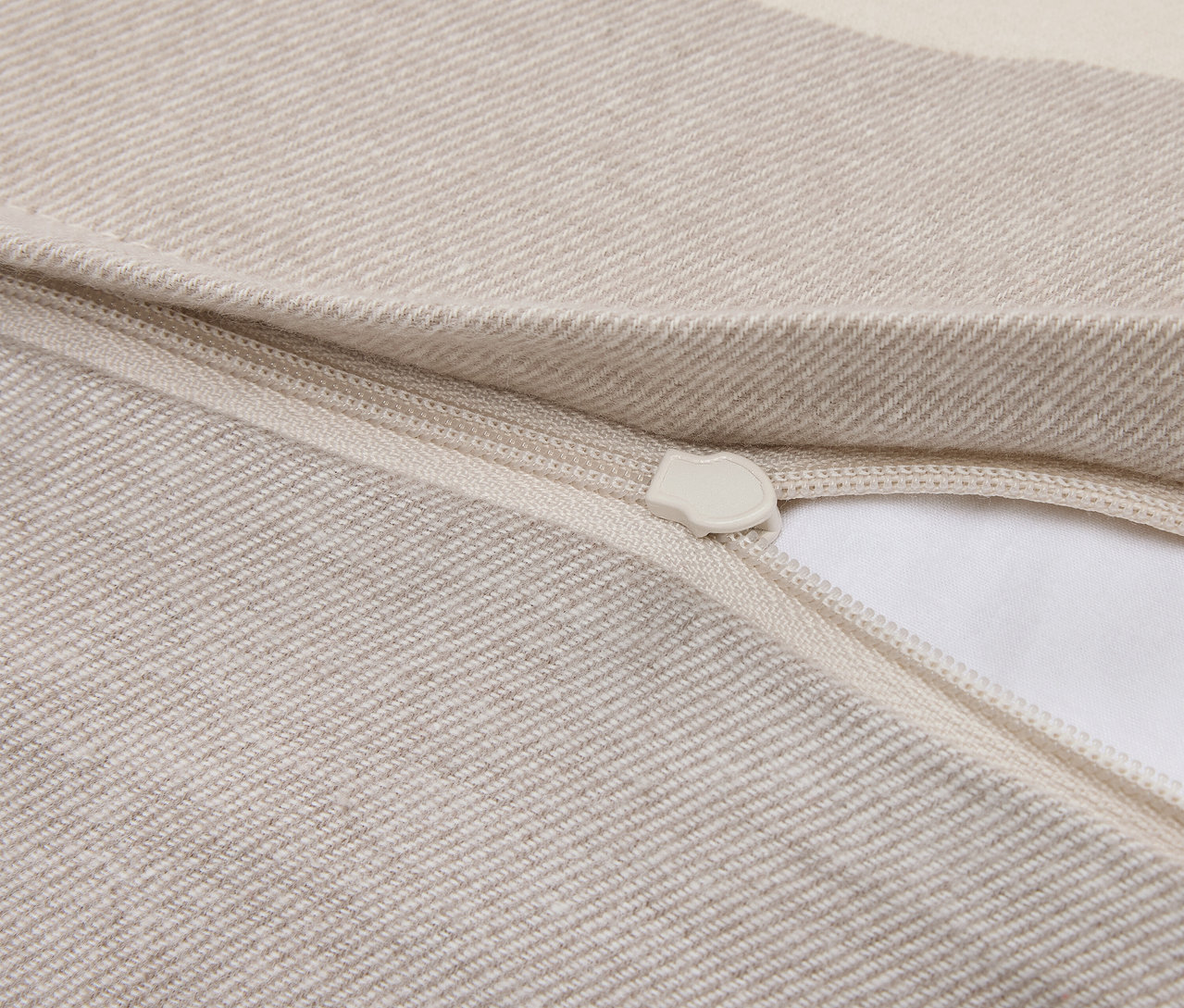 Detail béžovej obliečky na vankúš so zipsom.