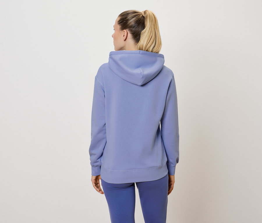 Žena v modrej súprave, chrbtom k fotoaparátu.